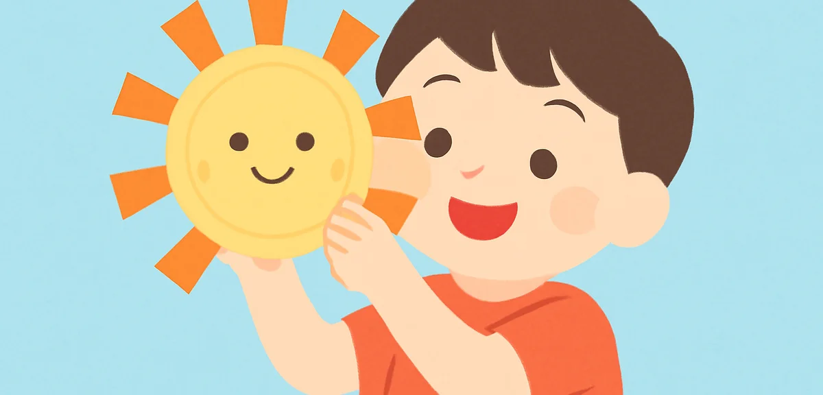 Smiling child holding a yellow paper plate sun craft decorated with orange paper rays, light blue ba