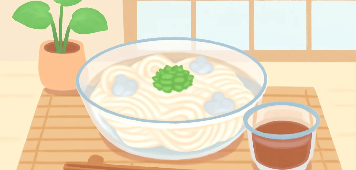 Cold somen noodles in a glass bowl with ice cubes, dipping sauce on the side, summer table setting i