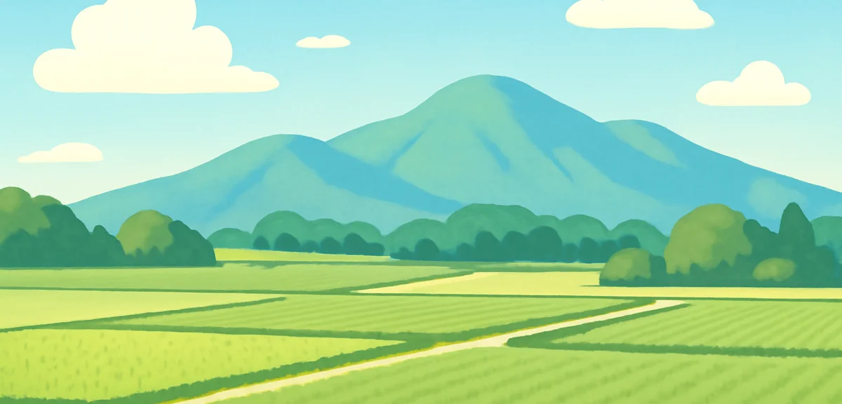 A peaceful summer landscape in northern Japan with green fields, distant mountains and a clear blue